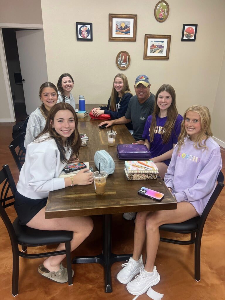 Randy sitting at kitchen table with teenagers discussing leadership and the gospel. This is who Randy calls the next generation leaders.